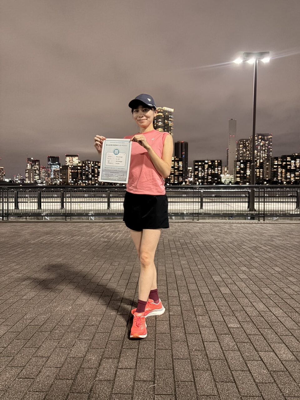 ランニングイベントの記念証を持つ高橋さん